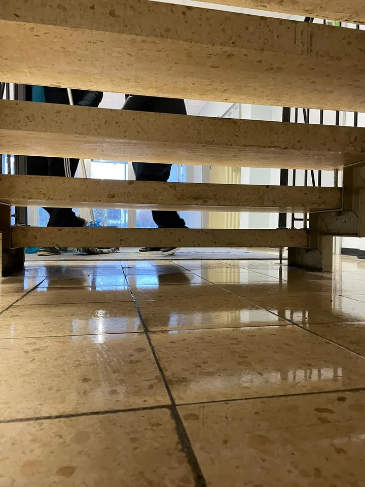 Frisch gewischter, glänzender Fliesenboden in einem Treppenhaus während der Unterhaltsreinigung